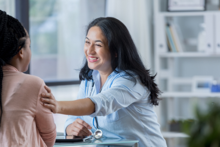 Female doctor with arm outreached to a patient