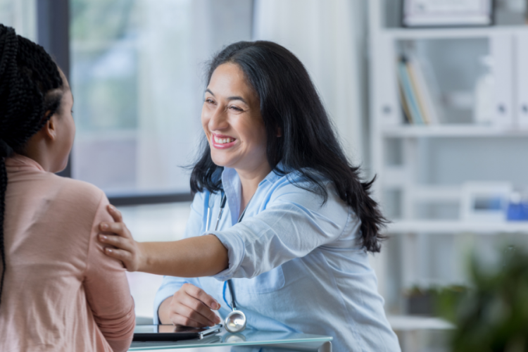 Female doctor with arm outreached to a patient 