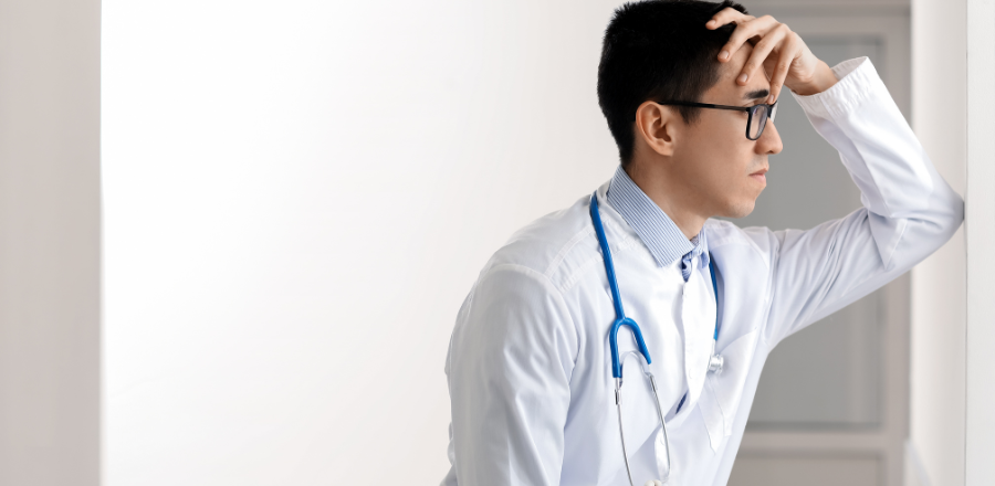 A young male doctor looking stressed