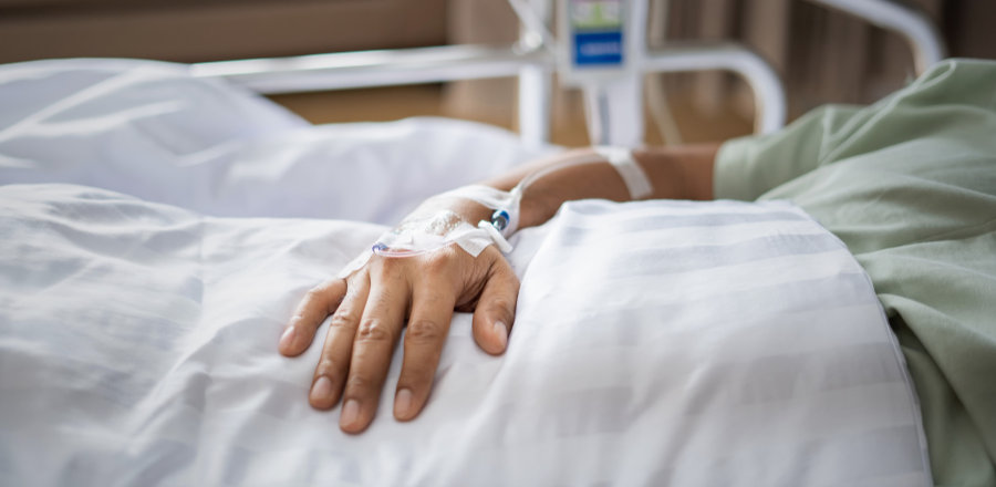 Hand of patient lying in a hospital bed