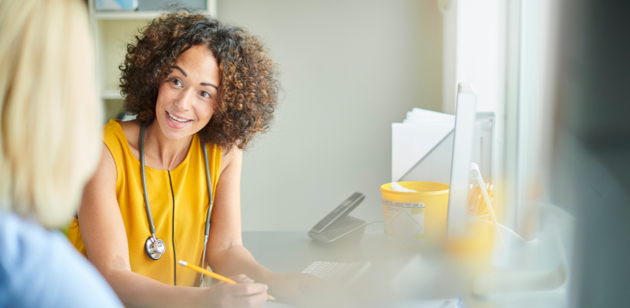 Female GP smiling in consultation room