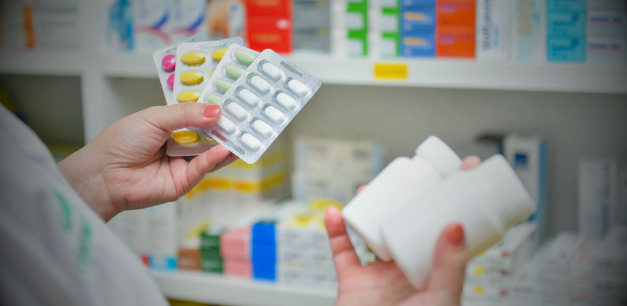 Close up of pharmacist inspecting medicines. Hands visible only