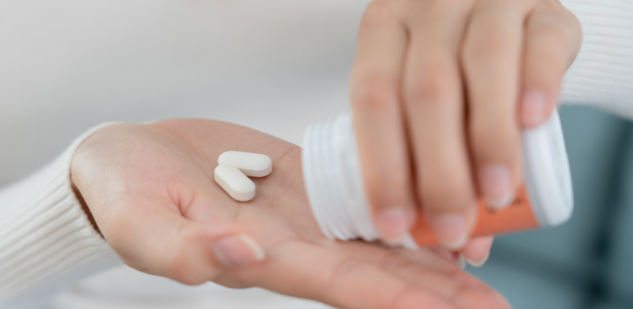 image of a person with pills in their hands